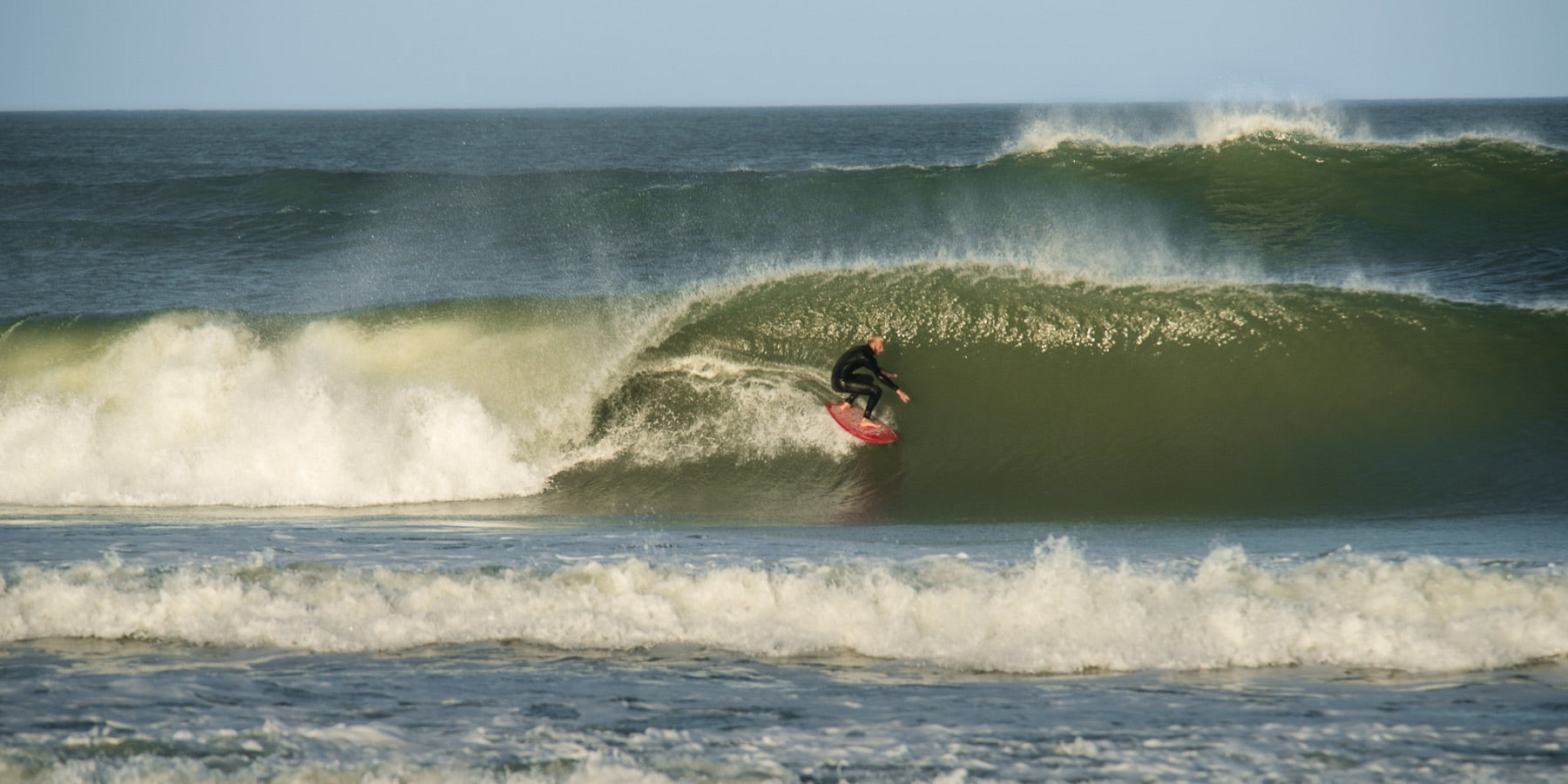 A surfer enjoys the Outer Banks surf of Avon North Carolina. 