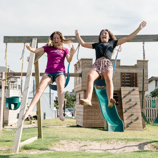 Two kid's enjoy Kavon Park's playground on Cape Hatteras. The kids are jumping off the swings and enjoying the Avon sunshine. 